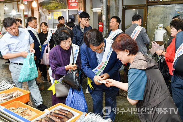 박남서 시장이 장보기 행사에서 생선을 영주사랑상품권으로 구입하고 있다