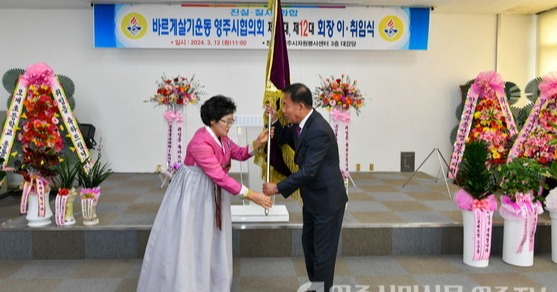 김남숙 이임회장(왼쪽)이 박용성 신임회장에게 바르게협의회기를 이양하고 있다