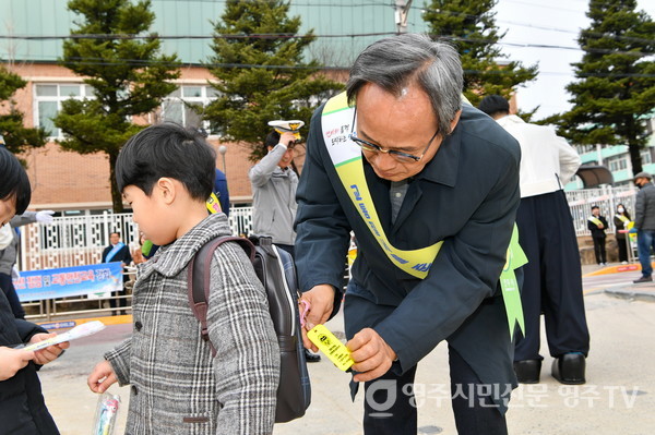 박남서 시장이 어린이에게 교통안전 물품 '옐로카드'를 달아주고 있다